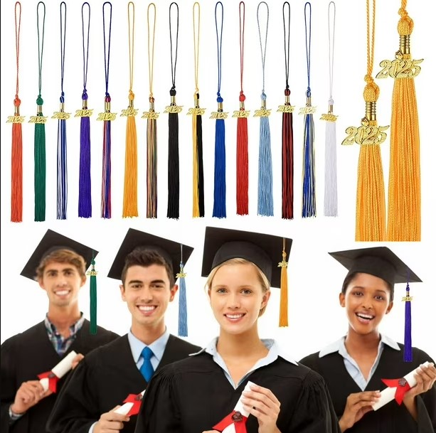 Close-up of a gold graduation cap tassel attached to the center button of a mortarboard